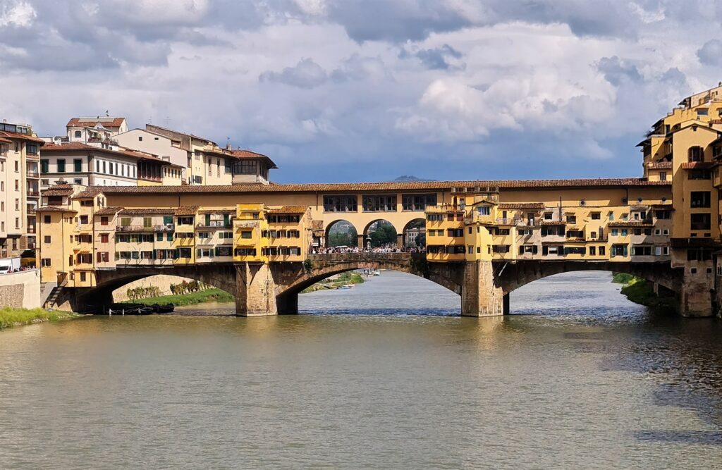 Le Ponte Vecchio sur l’Arno est l’un des symboles de la ville de Florence. Le corridor de Vasari surplombe une des deux rangées de boutiques et permettait aux Médicis de rejoindre le palais Pitti depuis le Palazzo Vecchio et les Offices sans les dangers de la rue.
